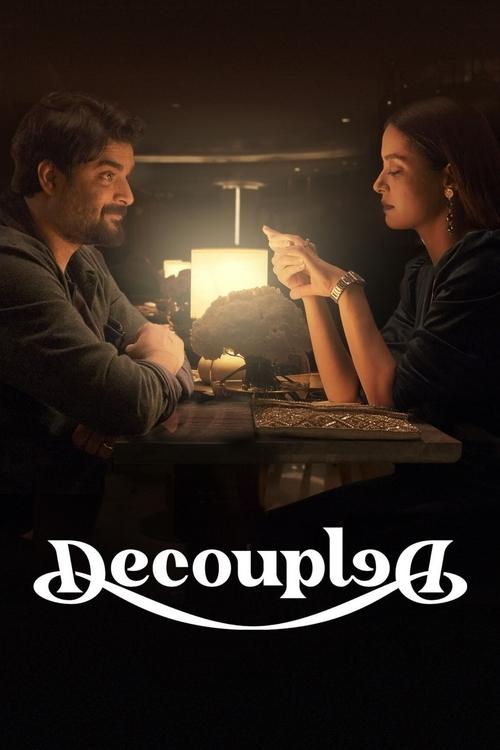 The poster features a dimly lit scene with two characters seated at a table, illuminated by warm, soft lighting. The mood is intimate and contemplative, suggesting themes of emotional distance or separation. The title "Decoupled" is elegantly displayed in a stylized font at the bottom, reinforcin...