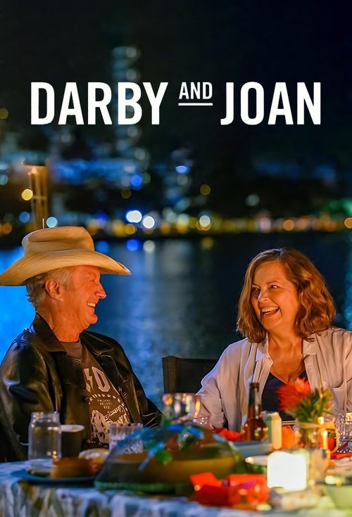 The poster features two people sitting at a table at night, with city lights in the background. The warm tones of their clothing and the soft glow of the table create a cozy, intimate atmosphere. The title "Darby and Joan" is prominently displayed in bold white letters, emphasizing the connection...