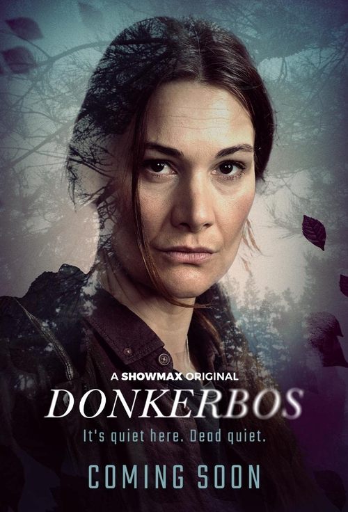 The poster features a woman with dark, tousled hair against a moody, atmospheric background of muted blues and greys. The title "Donkerbos" is prominently displayed in bold, white letters, with the tagline "It's quiet here. Dead quiet." below it. The overall mood is eerie and suspenseful, hinting...