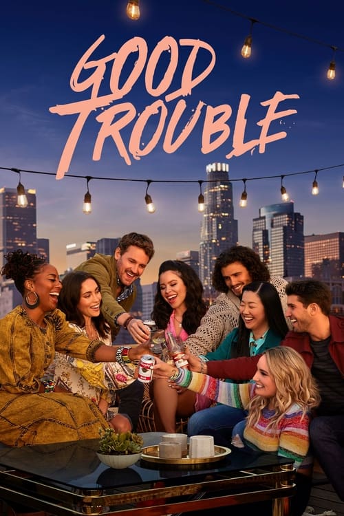 The poster features a lively group of eight people gathered around a table, suggesting a casual, friendly atmosphere. The warm colors of their clothing and the cozy setting evoke a sense of comfort and camaraderie. The title "Good Trouble" is prominently displayed in bold, playful lettering again...