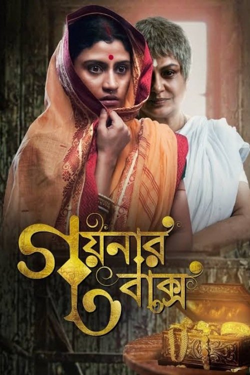 The poster features two women in traditional Indian attire, with warm earth tones and golden accents creating a mystical atmosphere. The title "Goynar Baksho" is prominently displayed in bold, stylized Bengali script. The image evokes a sense of cultural heritage and spiritual significance.