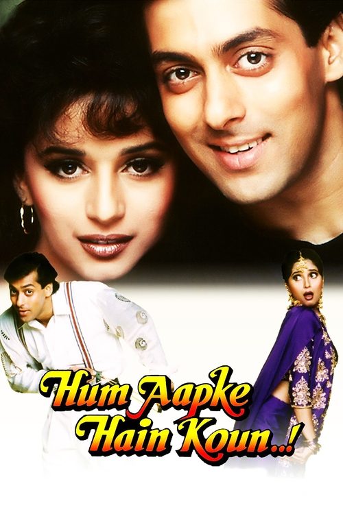 The poster features a close-up of actors Shailya Shetty and Rajkumar Hirani, exuding warmth and charm. The background is dark, making the vibrant colors of their outfits stand out. The title "Hum Aapke Hain Koun.." is prominently displayed in a playful font, suggesting a lighthearted and fun movi...