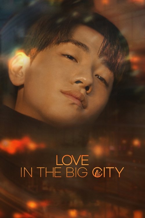 The poster features a young man with soft, dreamy eyes against a warm, glowing background of orange and red hues. The title "Love In The Big City" is elegantly displayed in gold lettering, evoking romance and urban romance. The overall mood is romantic and nostalgic, capturing the essence of a ci...
