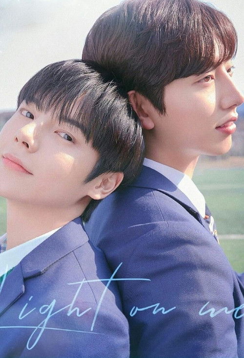 The poster features two young men in matching navy suits, leaning back against each other with a serene, contemplative mood. Soft natural lighting highlights their faces and the subtle blue tones of their attire, evoking a sense of calm and introspection.